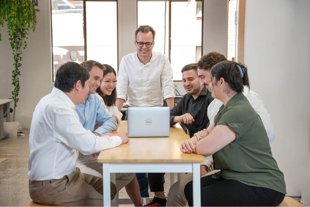 Photo of Sleek employees during meeting smiling and looking at presentation